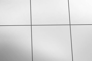 Düz tasarım ince koyu eklemli açık gri metal panel ızgarasını gösteriyor. Minimalist, mimari, yapısal, gösterişli, modern, kentsel, geometrik