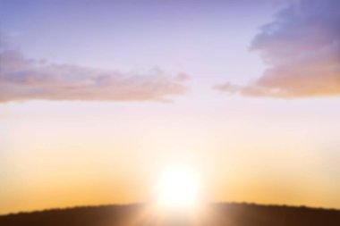 Gün batımında turuncu gökyüzüne karşı siluet manzara