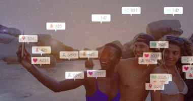 Gün batımında Sandy Plajı 'nda grup selfie' si için akıllı telefon uyarılarıyla poz veren dört arkadaş. Sahil, arkadaşlık, eğlence, hayat, yaşam tarzı, açık hava, sosyallik.