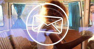 Kıvırcık saçlı, tahta panelleri ve açık mavi perdeleri olan eski karavanı kullanan bir kadın. Macera, yolculuk, klasik, seyahat, açık hava, keşif, nostalji.