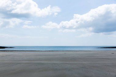 Geniş ıslak kumlu kıyı şeridi düz tasarım ile uzanıyor, sakin deniz, bulutlu gökyüzü, kayalık çıkıntılar. Huzur, manzara, minimalizm, doğa, sükunet, açık hava, çevre