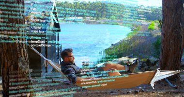 Göl kenarındaki ahşap kulübedeki hamakta kod kaplamalı dizüstü bilgisayarda kodlanan gözlüklü kodlayıcı dinleniyor. Gündelik, açık hava, huzur, doğa, modern, boş zaman, vahşi doğa.