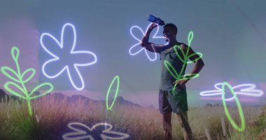 Spor giyim sektöründe erkek koşucu dağ sırtındaki çayır su şişesinden su içiyor. Kopya uzayı. Atletizm, sağlık, canlı, açık hava, motivasyon, doğa, fitness