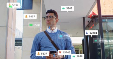 Akıllı telefon tutan İspanyol adamı kontrol ediyorum. Ofis girişinde çantalı uyarı simgelerini görüyorum. Teknoloji, iletişim, profesyonel, kentsel, stil, modern, dijital