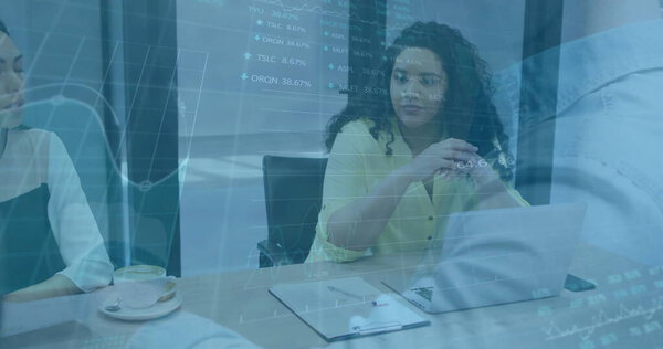 Женщина в жёлтой блузке ведет встречу в конференц-зале, с планшетом для ноутбука и картами акций. Коллаборация, профессионализм, стратегия, командная работа, корпоративное управление, лидерство, финансы