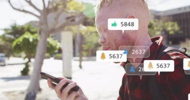 Telefonu ağzının kenarında tutan ve konuşan, sosyal medya ikonları üreten, nişan ölçümlerini yükselten bir adam. Teknoloji, bağlantı, dijital, iletişim, sosyal, açık hava, canlı