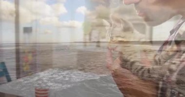 Yetişkin bir adamın kedi yavrusunu kaldırmasını kaplayan okyanus dalgaları. Şefkatli bir hayvan bakımı gösteriyor. Huzur, dostluk, sükunet, sahil, konfor, yumuşaklık, farkındalık.