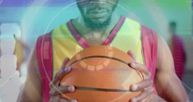 Basketbolcu topu kavrıyor ve nişan almadan önce dokuyu değerlendirmek için HUD teknolojisini devreye sokuyor. Sporcu, spor, teknoloji, hud, rekabet, odak, hareket