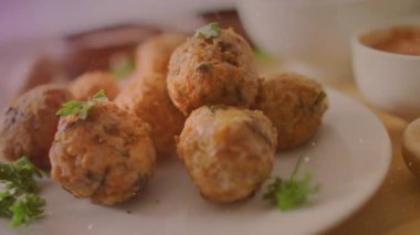 Çerçevenin açılışı seramik tabakta köfteler, ışık parlamaları renklendirici dokular. Aperatif, mutfak, gurme, köylü, davetkar, aşçı, organik