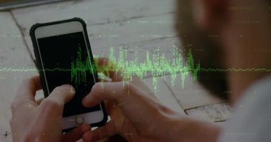 Yetişkin bir adam ahşap masadaki akıllı telefonu dinleyip yeşil dalga şeklindeki ses verilerini izliyor. Teknoloji, dijital, arayüz, kullanıcı, yenilik, ekran, veri