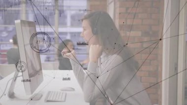 Destek çağrısı alınıyor, ajan mikrofonu ayarlıyor, ağ grafikleri arasında yazarken monitörü işaret ediyor. Teknoloji, iletişim, işbirliği, modern, profesyonel, dijital, çalışma alanı