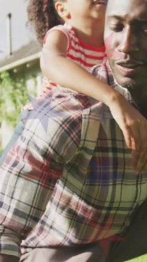 Afro-Amerikan baba ve kızının eğlenmesi üzerine kırmızı, mavi ve beyaz yıldızların animasyonu. Amerikan vatanseverliği ve bağımsızlık kavramı dijital olarak oluşturulmuş video.