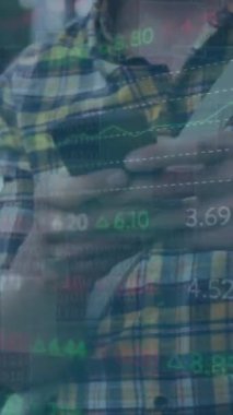 Şehirdeki akıllı telefon kullanan beyaz bir adam hakkında finansal veri işleme animasyonu. Küresel finans, iş, bağlantılar, hesaplama ve veri işleme kavramı dijital olarak oluşturulmuş video.