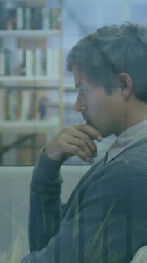 Animation of multiple graphs and leaves over focused caucasian businessman working over laptop. Digital composite, multiple exposure, report, nature, technology, working, professional and office.