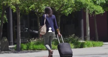 Yaya geçidine ulaşan, iş kadını bavulunu ve çantasını çekiyor, ofis girişine doğru ilerliyor. Şehir, iş, seyahat, profesyonel, atmosfer, tarz, açık hava