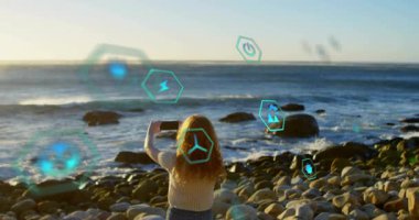 Okyanus üzerinde akıllı telefon yetiştiren ve çevresel verileri izlemek için AR 'ı etkinleştiren bir kadın. Gelecek, dijital, teknoloji, arayüz, yenilik, sürdürülebilirlik, açık hava