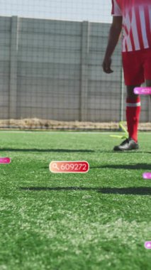 Animation of social media icons over mid section of male soccer players practicing on sports field. Social media networking and sports concept