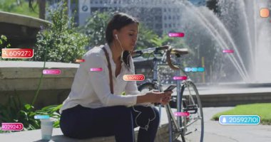 Kadın kulaklık takıyor, akıllı telefonu çeşmeyle dinliyor, dijital tebligatlar yaratıyor. Kentsel, teknoloji, iletişim, eğlence, modern, etkileşim, bağlantı