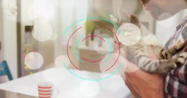 Dönen yüzükler, kedi yavrusunu masada tutan adama, kedi yavrusunun evcil hayvan bakımı için parmağını yalamasını gösteriyor. Dijital, minimalist, çağdaş, yaşam tarzı, uyum, sıcaklık, samimiyet