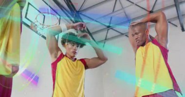 Basketbol takım arkadaşları halkanın altında trisepslerini esnetmeye, neon halkalarını sallamaya başladılar. Sporcular, fitness, training, sport, neon, urban, motive