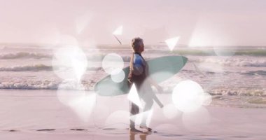 Sörf yapan kıdemli sörfçü dalgalara doğru sörf tahtası taşıyor, hafif bokeh sürükleniyor. Macera, esneklik, sükunet, okyanus, kıyı şeridi, zarafet, aktif yaşam tarzı