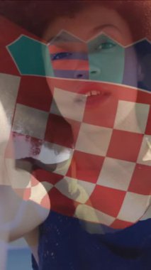 Hırvat bayrağının sahilde kamerayla konuşan bir kadının üzerinde sallanmasının animasyonu. Dijital bileşim, çoklu pozlama, özgürlük, hükümet, vatanseverlik ve teknoloji kavramı.