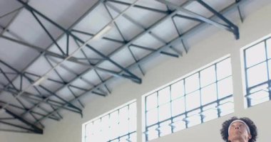 Arıza spor salonunu temizliyor, top sektiren oyuncu, sayı yapmak için arka tahtaya doğru smaç basıyor. Dinamik, atletik, spor, performans, canlı, enerjik, modern