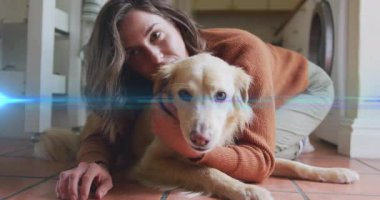 Evcil hayvan sahibi yerde diz çökmüş krem rengi köpeğe sarılmış, mercek alevi süpürüyor, köpek kameraya yaklaşıyor. Arkadaşlık, sıcaklık, şefkat, konfor, yaşam tarzı, samimiyet, çağdaş