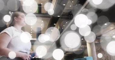 İş kadını bokeh ışığı altında atriyuma giriyor ve iş uygulaması için akıllı telefonu dinliyor sonra da çıkıyor. Modern, iç mekan, yaşam tarzı, teknoloji, çalışma alanı, çağdaş, rahat