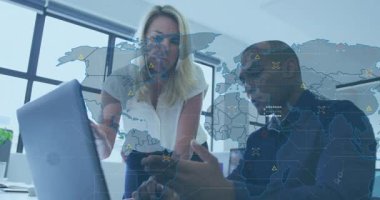 İş arkadaşları telefon verilerini kaydırırken dizüstü bilgisayarın dünya haritasını etkinleştirdiğine işaret ediyorlar. İşbirliği, teknoloji, veri, sunum, iletişim, ofis, meslek