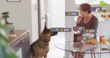 Kadın kahve dolduruyor ve masada yemek yiyor. Yüzen sosyal medya simgeleri ateşliyor. Modern, yaşam tarzı, rahat, dijital, etkileşim, yerli, canlı