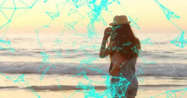 Kadın kıyıya geliyor dürbünü kaldırıyor, ufuk çizgisini tarıyor ve teknik turkuaz ağ genişliyor. Deniz manzarası, keşif, yenilik, fütürizm, sükunet, keşif, dijital alarm