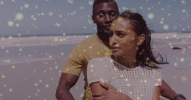 Bir adam kumsalda kadının arkasına geçiyor, altın sarısı kıvılcımlar saçıyor düğün için romantik kucaklaşmalar paylaşıyor. Romantizm, samimiyet, şefkat, sükunet, bağlantı, deniz kenarı, arkadaşlık