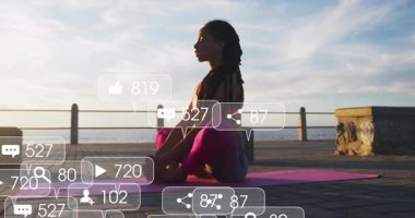 Yoga yapan kadın, güneşin doğuşunu seyrederek sosyal ölçümlerin yükselişini izliyor ve azalıyor. Sağlık, farkındalık, dinginlik, dijital bağlantı, fitness, açık hava, gün doğumu