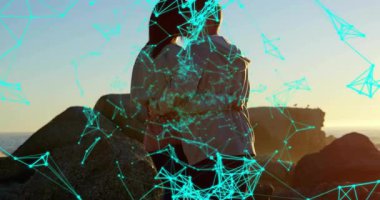 Dijital turkuaz teknoloji ağı sahil günbatımını süpürüyor sürüklenen düğümler çift kucaklaşmasını gösteriyor. Bağlantılar, samimiyet, teknoloji, dinginlik, manzara, ambiyans, uyum