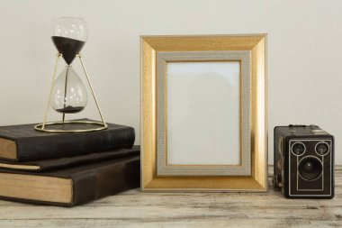 Fotoğraf çerçevesi, kitap ve hoparlör masada, yakın plan.