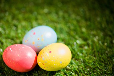 Bahçedeki çimlerin üzerinde renkli Paskalya yumurtaları