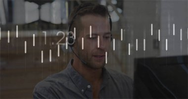 Monitoring agent wearing headset sitting at desk with screen in office, viewing overlay charts. Technology, communication, productivity, analytics, modern, corporate, collaboration