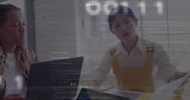 Meslektaşlar, toplantı odasında hardal sarısı tulumlarla yazılı belge ve dizüstü bilgisayarı inceliyor. Profesyonel, takım çalışması, modern, teknoloji, veri, analiz, işbirliği