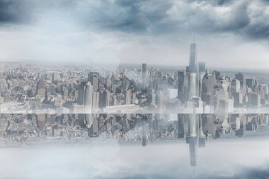 Büyük pencereli oda binaları olan şehre bakıyor.