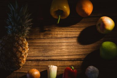 Sunlight falling on wooden table surrounded by fruits and vegetables