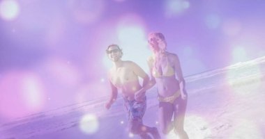 Güneş gözlüğü ve mayo takmış, kumsalda el ele tutuşan bir adam ve kadın. Romantik, çift, tatil, açık hava, rahatlık, dinginlik, coşku