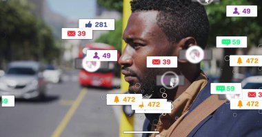 Ceketli adam, yüzen sosyal simgelerle, araçlarla, kopyalama alanıyla sokakta sarı direğin yanında duruyor. Kentsel, teknoloji, iletişim, profesyonel, modern, dinamik, açık hava