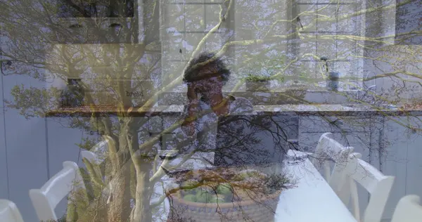 Evde mutfak masasında şapkalı, akıllı telefonlu yeşil elma ve ekmek kutusuyla konuşan bir kadın. Yurt içi, yaşam tarzı, minimalist, refah, nesiller arası, rahat, sağlık