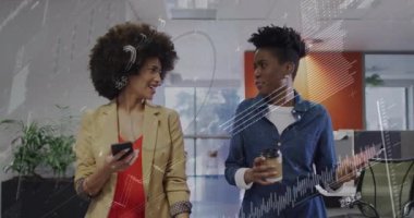 Ofiste yürüyen iki meslektaş, akıllı telefon ve veri yükleme ile ilgili iş verilerini paylaşıyor. İşbirliği, takım çalışması, analitik, iletişim, modern, çalışma alanı, profesyonel