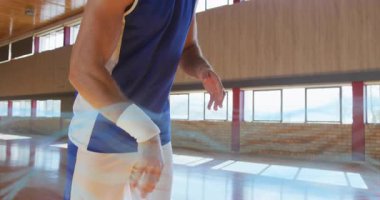 Erkek sporcu, turuncu basketbol topunun salyalarını sallıyor. Spor sahasında çember atışı yapıyor. Spor, atletizm, eğitim, rekabet, performans, hareket, kararlılık