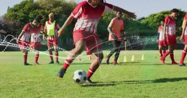 Futbol oyuncuları koni ve direğin arkasında diziliyorlar. Lider oyuncu topu kontrol etmek için öne çıkıyor. Atletik, takım çalışması, çeviklik, eğitim, sportmenlik, açık hava, enerjik