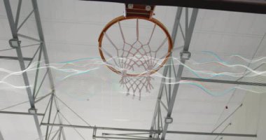 Kolları kırmızı forma giyiyordu. Spor salonunda sayı yapmak için potaya girip basketbolu potaya sokuyordu. Eylem, spor, atletik, rekabet, dinamik, kentsel, canlı