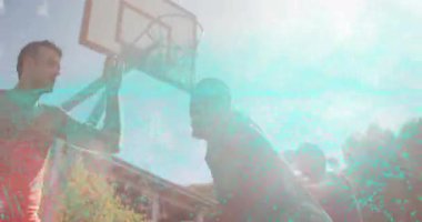 Basketbol oynayan üç adam potaya doğru gidiyor. Topu serbest bırakıp potaya vuruyor. Atletizm, takım çalışması, aktif, açık hava, spor, gençlik, spor