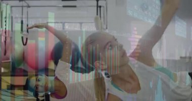 Pilates katılımcıları, çekirdek gerilmesi için kollarını senkronize bir şekilde kaldırıyorlar. Spor, sağlık, egzersiz, esneklik, stüdyo, uyum, hareket